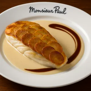 A serving of fish topped with a layer of thinly sliced potatoes
