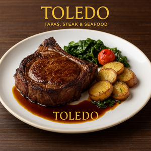 Uma costeleta suína defumada em um prato com molho do Toledo Tapas, Steak & Seafood